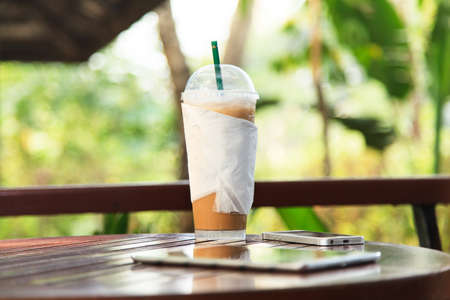 Iced coffee with tablet and phoneの写真素材