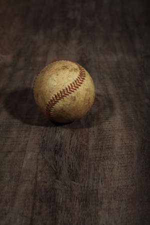Weathered baseball on wood backgroundの写真素材