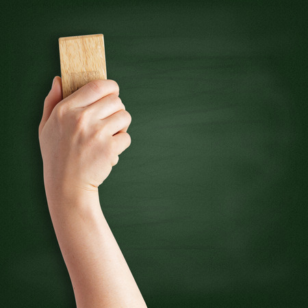 Teacher cleaning the chalkboard with a chalk dusterの写真素材