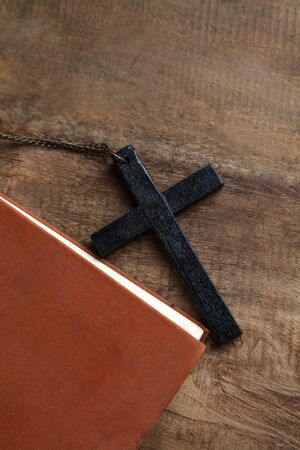 Cross over wood table with old book, holy Bibleの写真素材