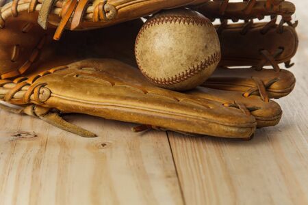 Old baseball glove with baseball on wood backgroundの写真素材