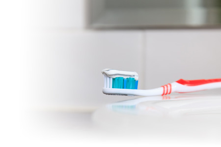 Toothbrush with toothpaste in the bathroom sink