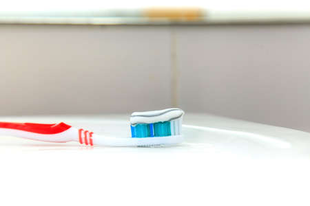 Toothbrush with toothpaste in the bathroom sinkの写真素材