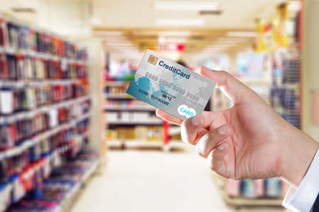 Hand holding credit card for shopping at shopping mallの写真素材