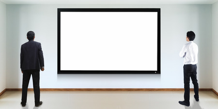 Businessman standing looking at the TV screen
