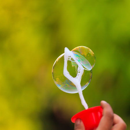 Children's hand with soap bubbleの写真素材