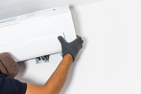Technician air conditioning setup and installs the new air conditioner in new homeの写真素材