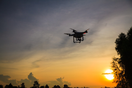 Silhouette of drone flying at sunset