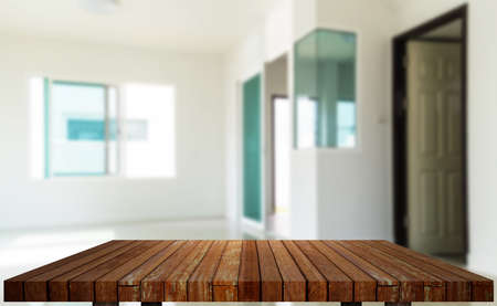 Wooden table in front of blurred empty modern interior room backgroundの写真素材