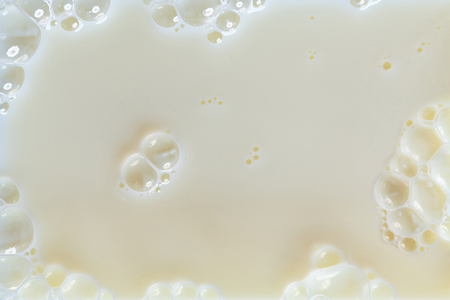 Milk Splash, frothy white milk creating bubbles backgroundの写真素材