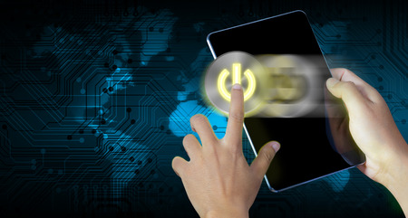 Hand press power button on a digital tablet screen with abstract technology background