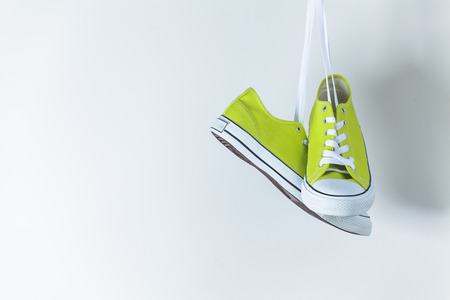 Pair of new green sneakers hanging on the wallの写真素材