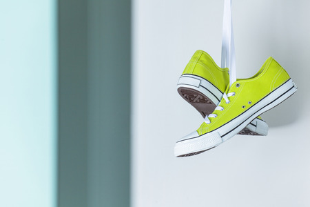Pair of new green sneakers hanging on the wallの写真素材