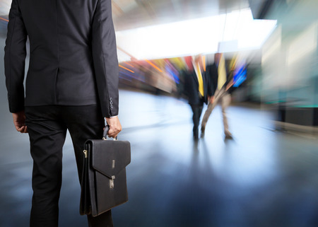 Businessman holding a briefcase in a modern officeの写真素材