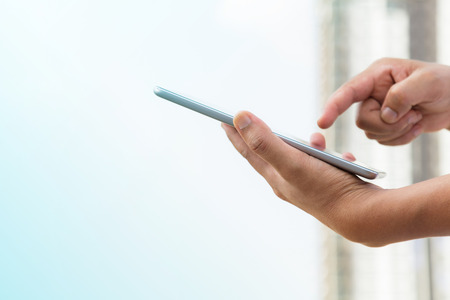 Hands of businessman working on digital tablet outdoor