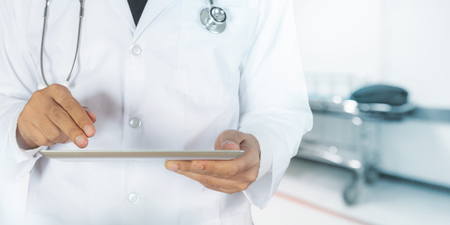 Healthcare and Medicine, Doctor using a digital tablet in Hospital roomの写真素材