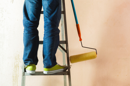 Painter painting the walls white in houseの写真素材