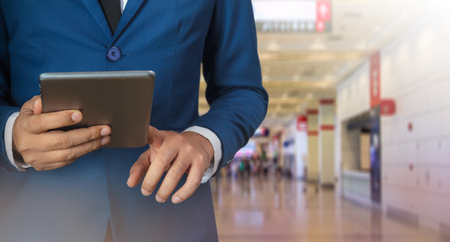 Businessman using digital tablet with modern building and social mediaの写真素材