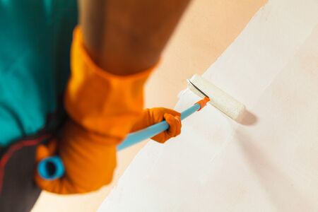 Painter painting the walls white in houseの写真素材