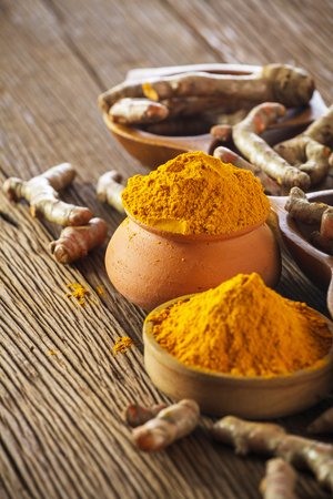 Turmeric roots on wooden backgroundの写真素材