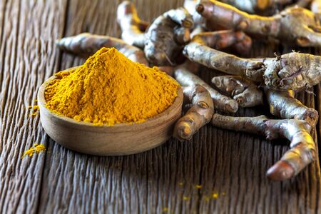 Turmeric roots on wooden backgroundの写真素材