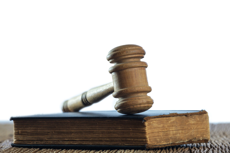 Judge's gavel with old book on old wood tableの写真素材
