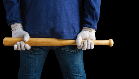Man holding a baseball bat on black backgroundの写真素材