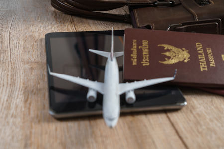 Small plane model, Thai passport, Leather bag, Tablet on wooden board background, Travel conceptの写真素材