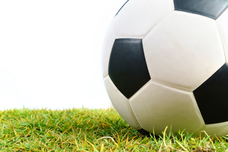 Soccer ball on green grass isolated on white backgroundの写真素材