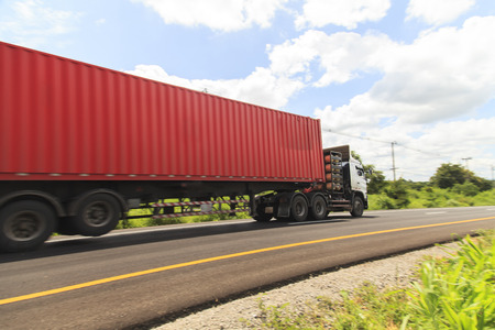 Red truck on the highway under the blue sky