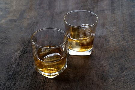 Top view of Whiskey with ice in glass on wooden tableの写真素材