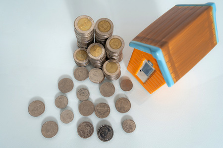 The concept of saving money, Small house and coin on black backgroundの写真素材