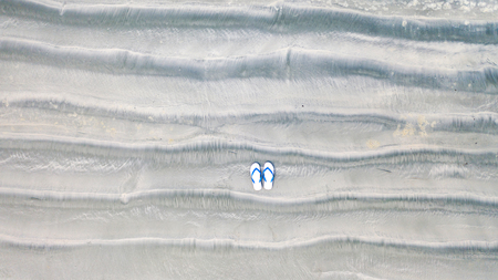 Flip-Flops on Sand beach, Summer holiday background, Aerial top viewの写真素材