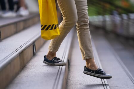 Close up of legs and shoes walking on street in the city