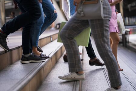 Close up of legs and shoes walking on street in the city