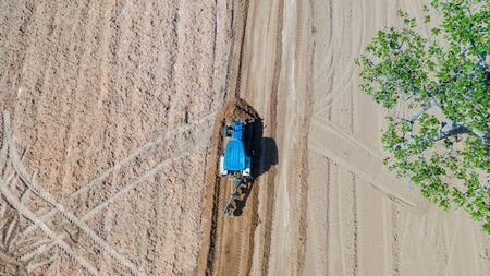 Top view of agricultural tractor vehicles working at field