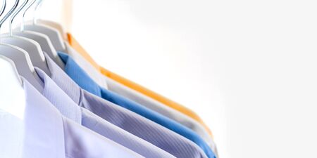 Close Up of Men's dress shirts, Clothes on hangers on white background