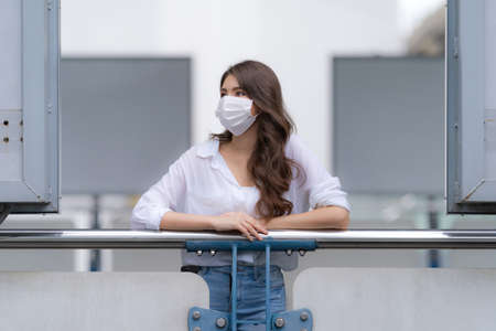 Portrait of young woman with smiley face wearing face mask protective walks in a city