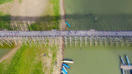 Aerial top view of Wooden bridge with tour boat at Sangklaburi in Kanchanaburi province, Thailand