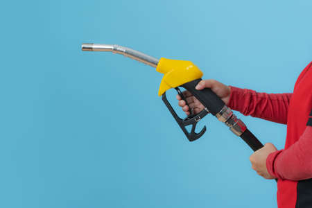 Woman hands holding fuel nozzle isolated on blue background