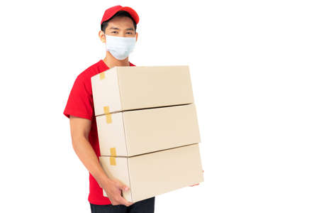 Smiling delivery man employee in red cap blank t-shirt uniform standing with parcel post box...