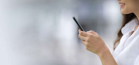 Outdoors portrait of Happy young woman using a phone in the city