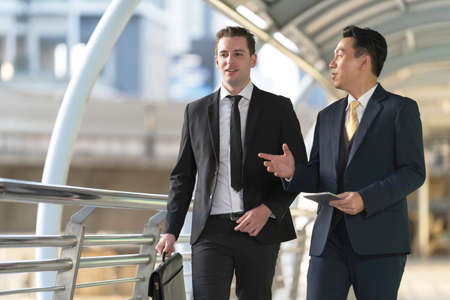 Business people walking and talk to each other in front of modern officeの写真素材