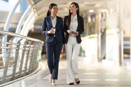 Business people walking and talk to each other in front of modern office