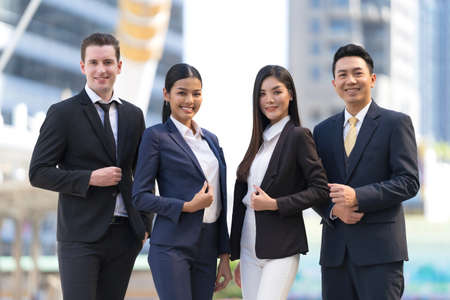 Four executives in a row, Business team standing and cheering in front of modern office, Leadership Concept, Business success win resultの写真素材
