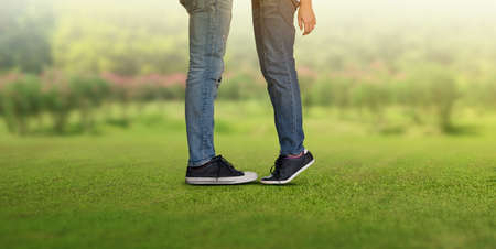 Couple kissing, girls stands on tiptoe to kiss her man, legs of a guy and a girl they kissの写真素材