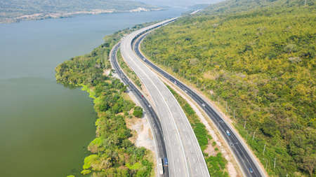 Scenic aerial view of big highway, Top view from drone of road and green forest mountain in thailandの写真素材