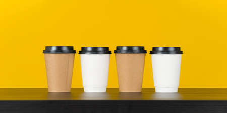 Blank paper coffee cup set on yellow backgroundの写真素材