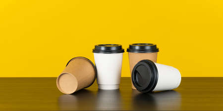 Blank paper coffee cup set on yellow backgroundの写真素材