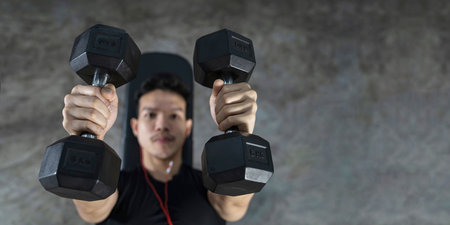 Close-up of fitness man, Handsome athletic guy workout with dumbbellsの写真素材